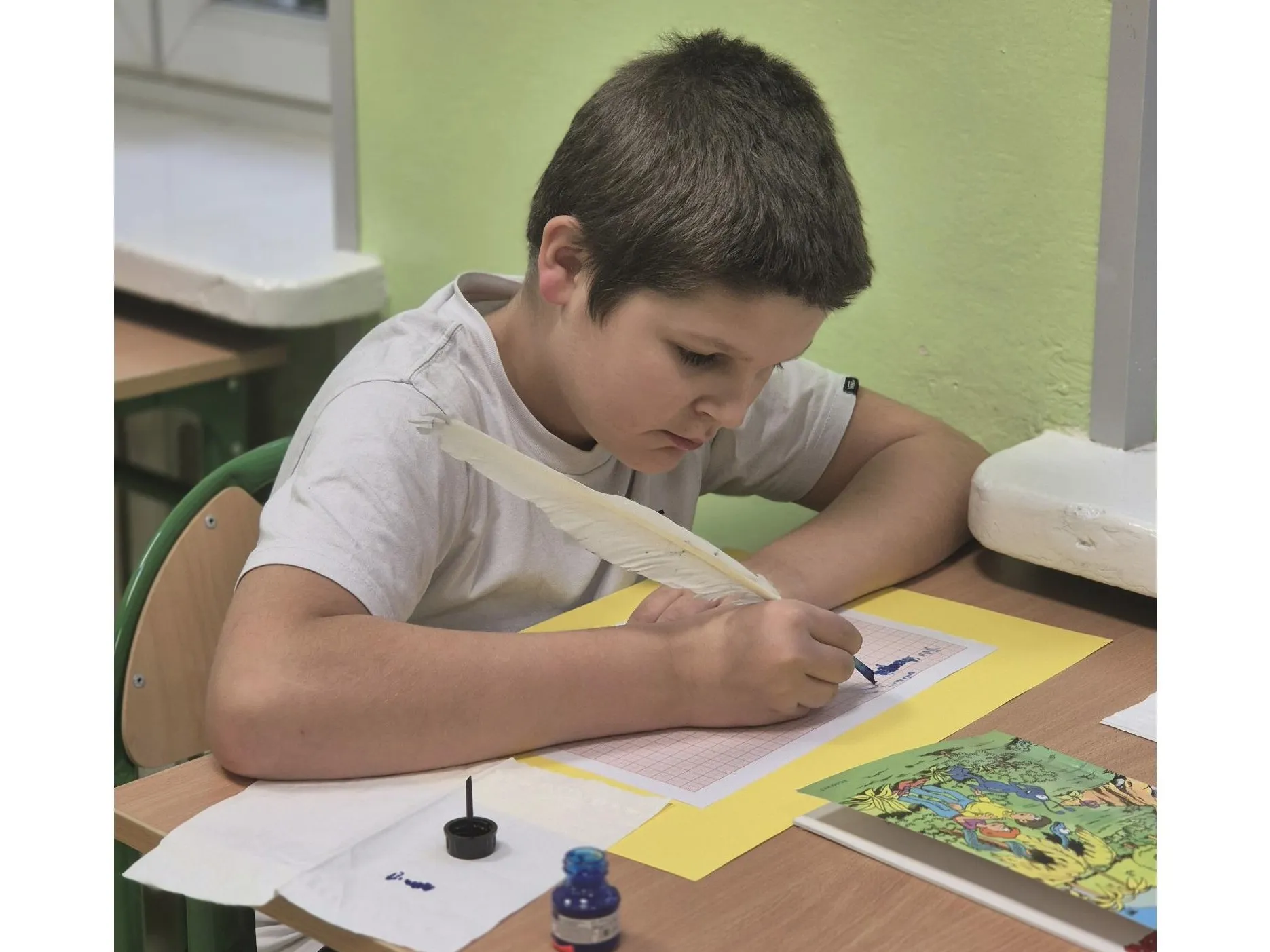 Uczeń pisze piórem